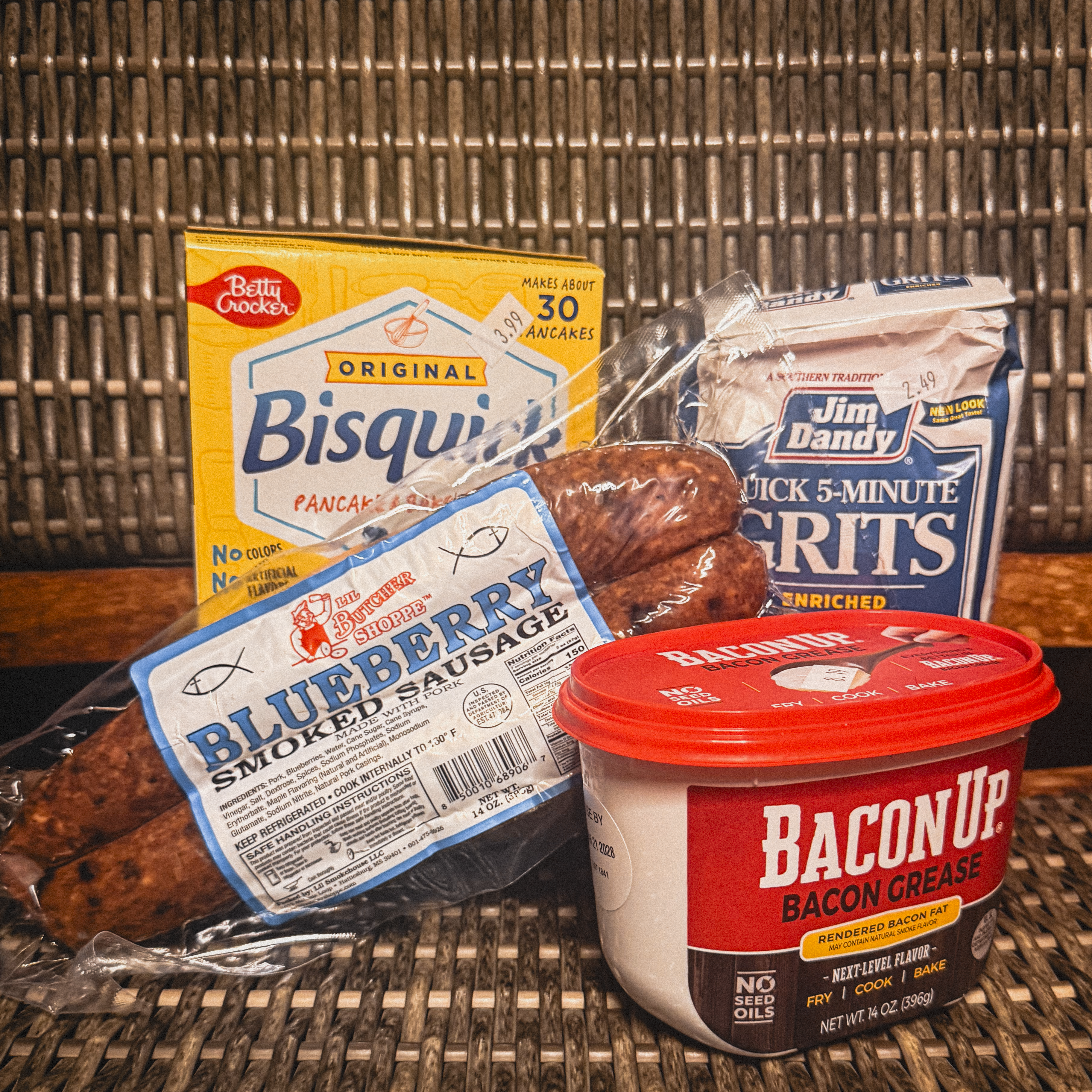 Lil Butcher Shoppe Blueberry Smoked Sausage with pancake mix, quick grits and a tub of bacon grease