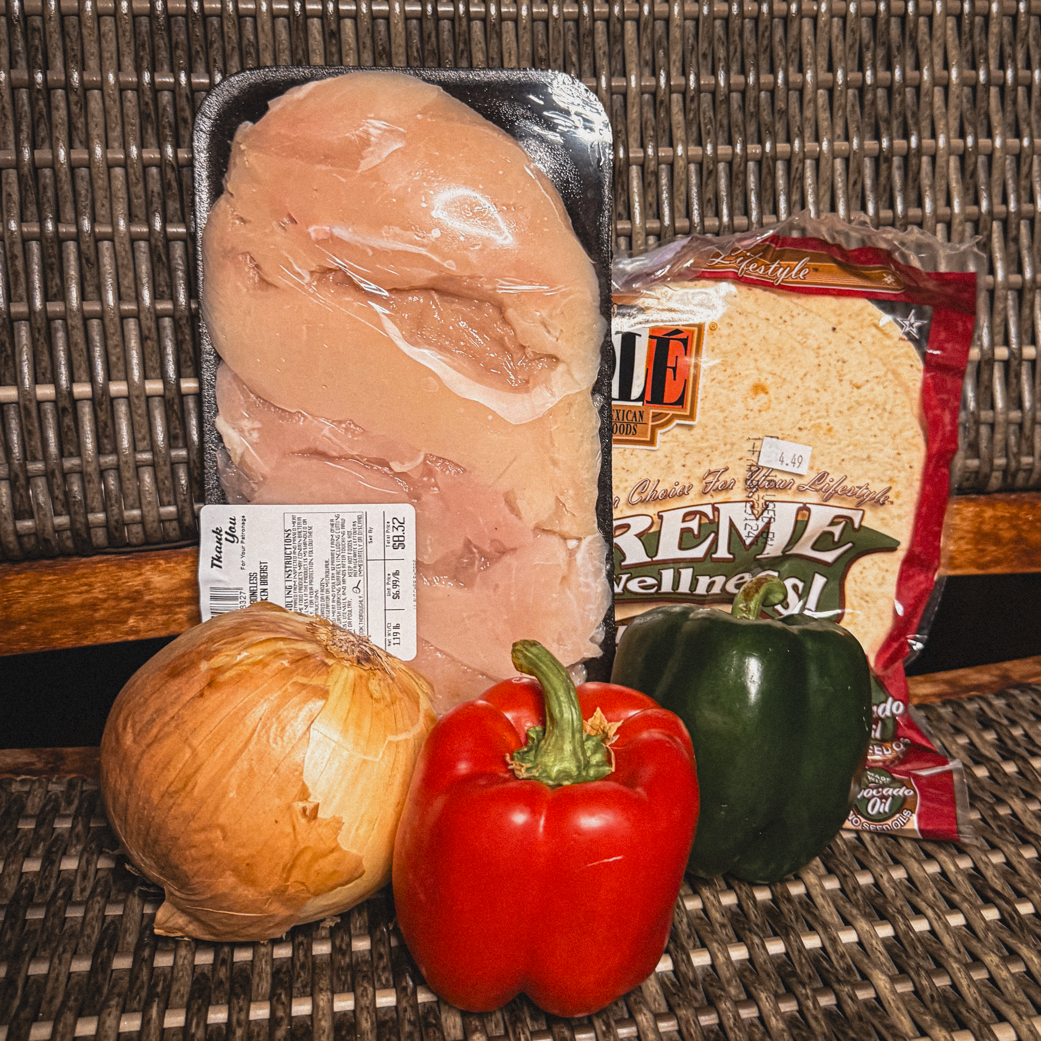 Fresh boneless chicken breasts from Lil Butcher Shoppe with flour tortillas, red and green bell peppers and a yellow onion
