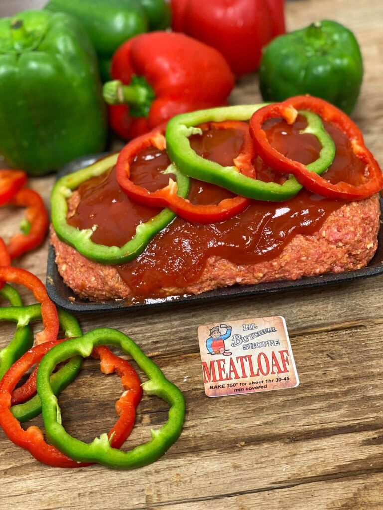 Lil Butcher Shoppe homemade meatloaf topped with sauce and red and green bell pepper rings